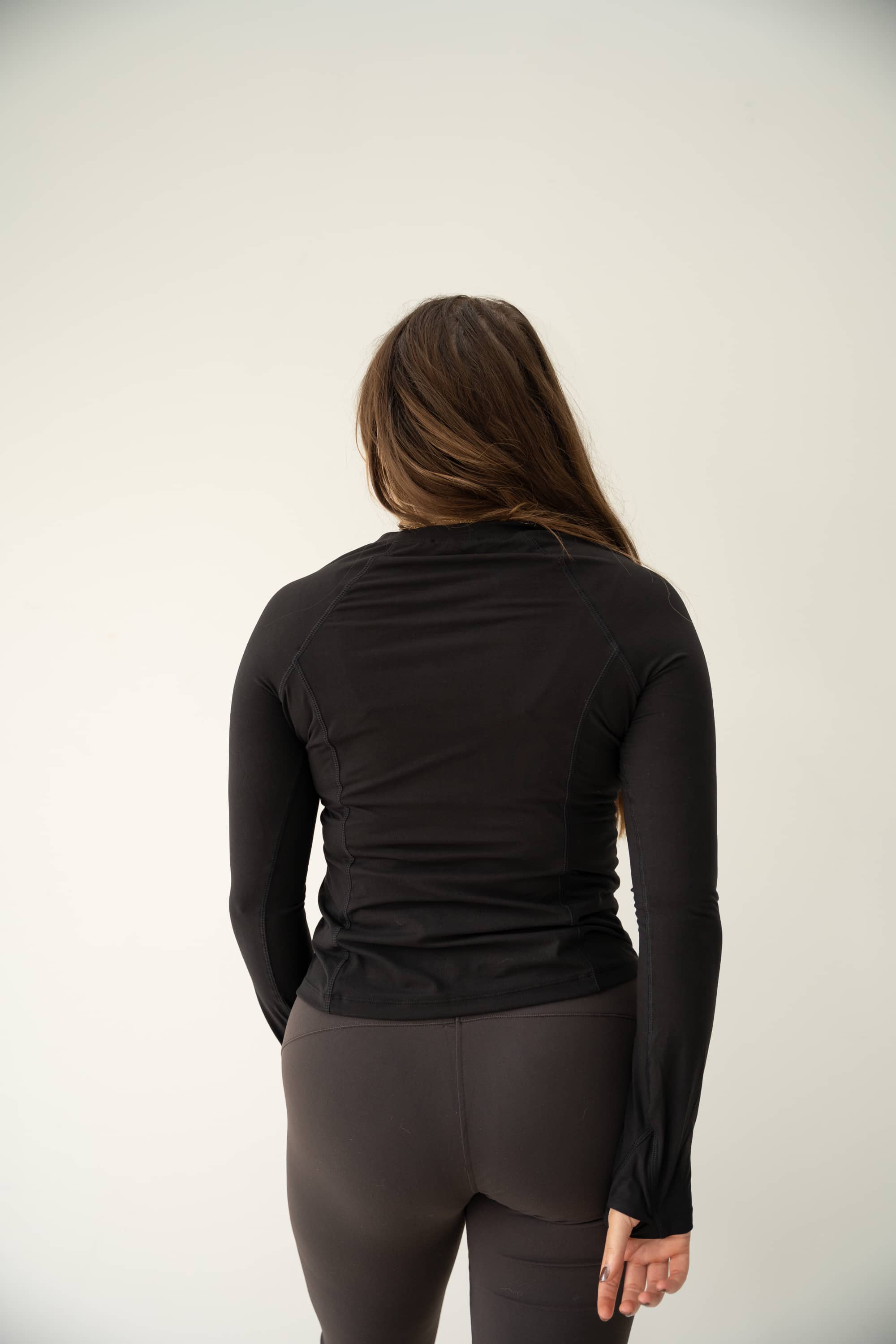 Long-sleeved performance shirt in Black with thumbholes.