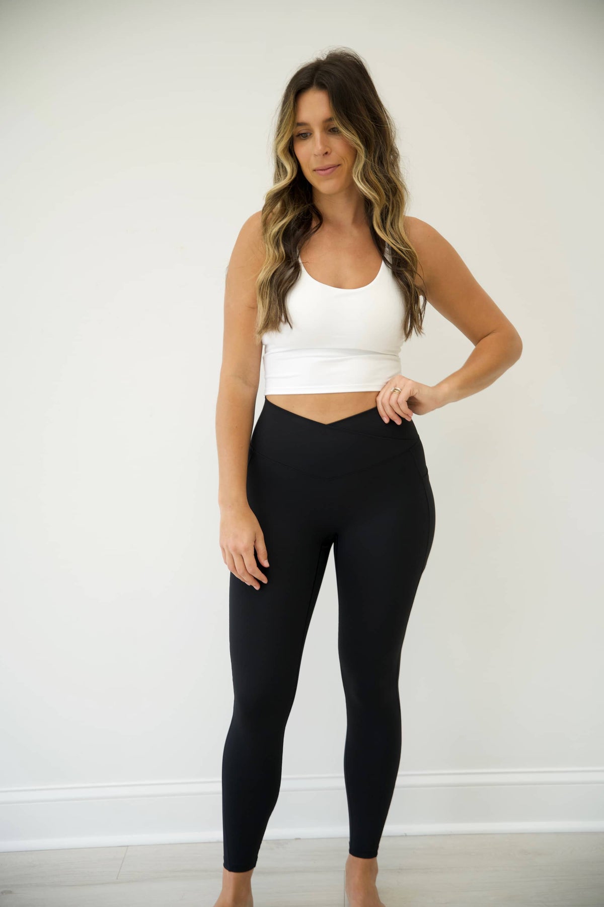 Black LUMINOUS Crossover waist leggings with two side pockets.